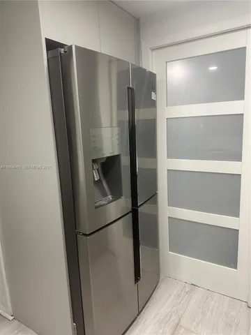 a metallic refrigerator freezer sitting in a kitchen