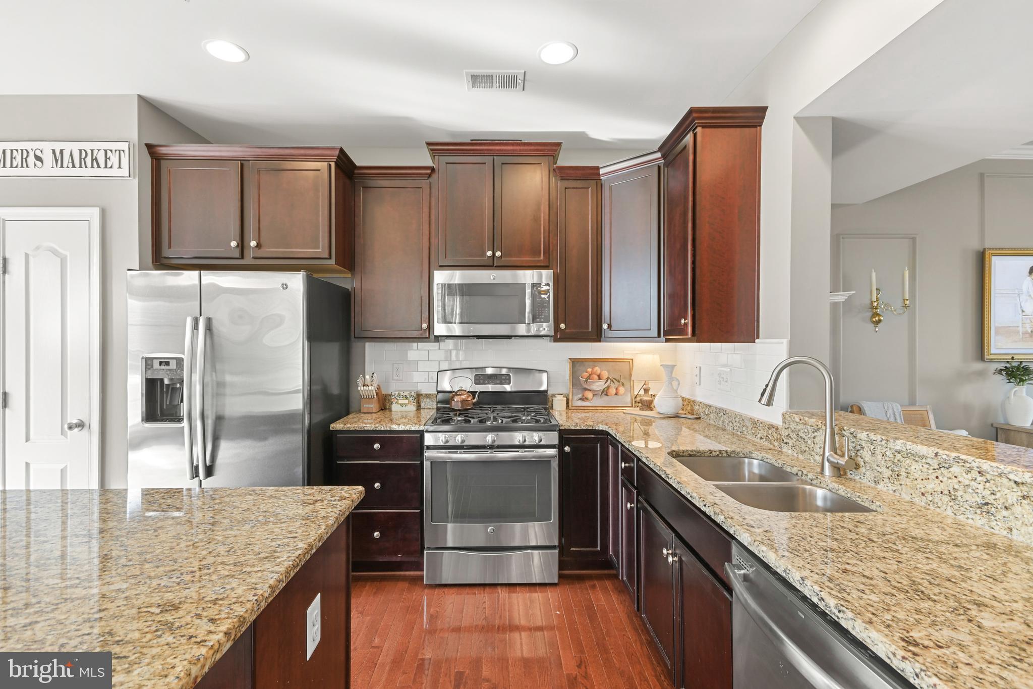 2709 Osprey Way North Frederick, MD 21701 - Photo 24 of 64 a kitchen with kitchen island granite countertop a sink stove refrigerator and cabinets