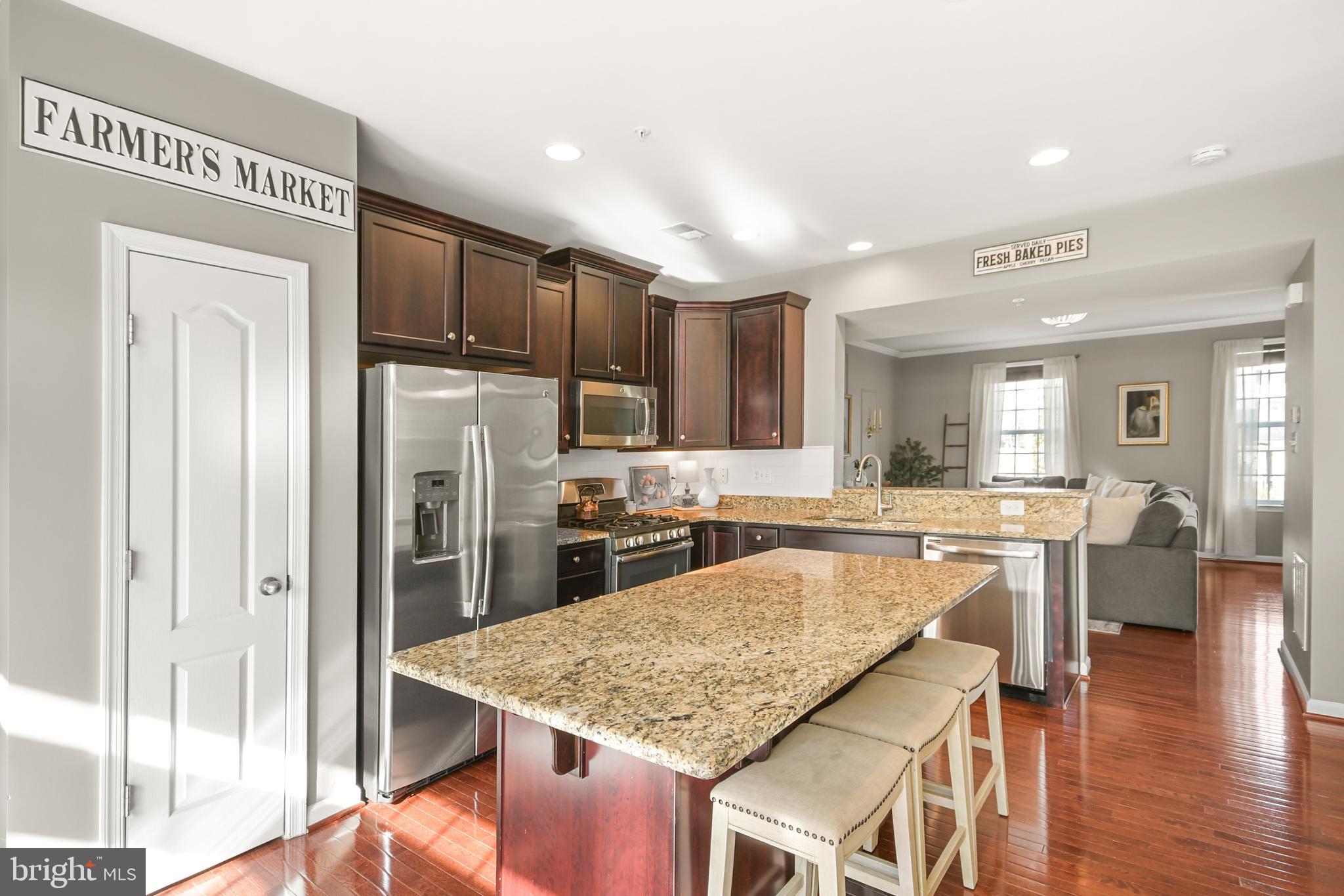 2709 Osprey Way North Frederick, MD 21701 - Photo 27 of 64 a kitchen with stainless steel appliances granite countertop refrigerator sink cabinets dining table and chairs