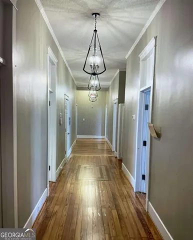 a view of a hallway with wooden floor and staircase