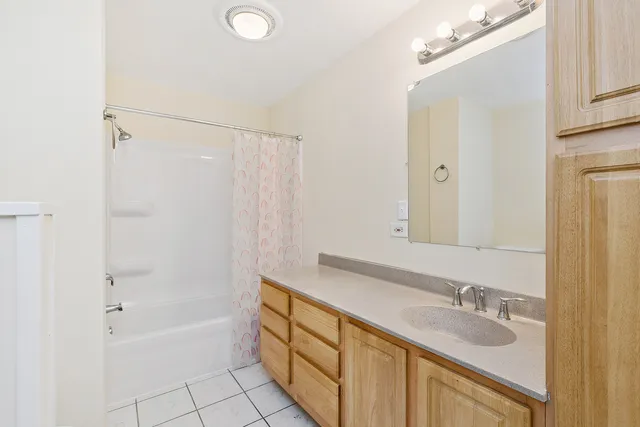 a bathroom with a granite countertop sink a mirror and a bathtub