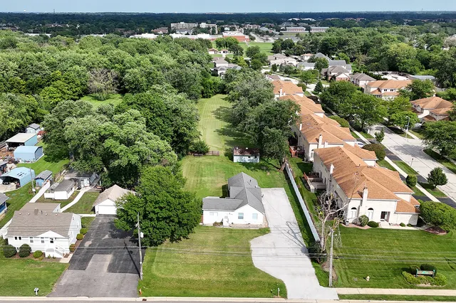 an aerial view of a house with a yard swimming pool patio and outdoor seating