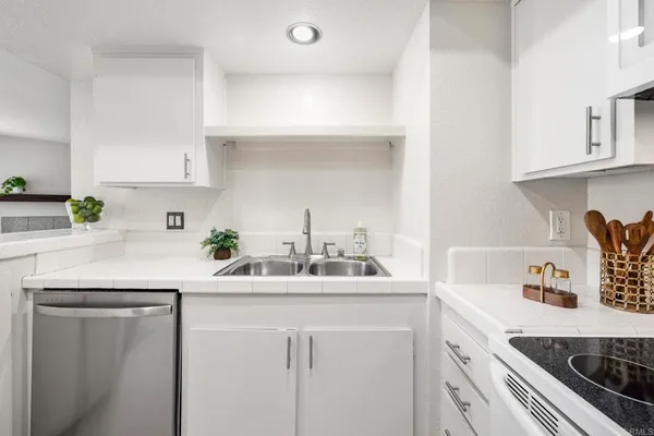 a kitchen with kitchen island a sink a stove and cabinets