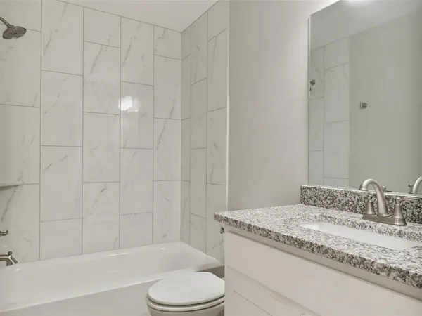 a bathroom with a granite countertop sink toilet and shower