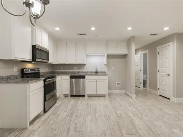a large kitchen with stainless steel appliances granite countertop a stove a sink and a refrigerator