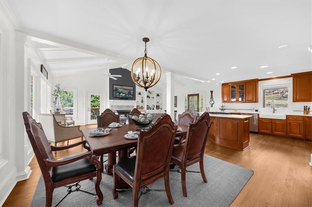 9230 Four Mile Creek Road Gainesville, GA 30506 - Photo 14 of 67 a dining room with wooden floor a chandelier a wooden table and chairs