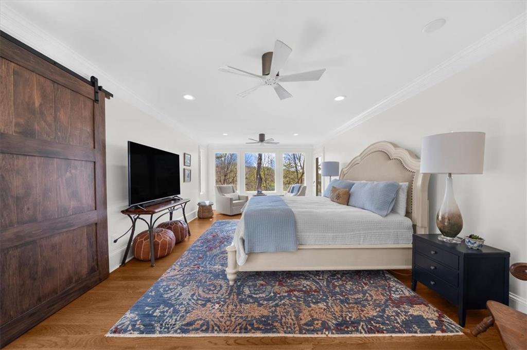 9230 Four Mile Creek Road Gainesville, GA 30506 - Photo 18 of 67 a bedroom with a bed a flat screen tv and view of bathroom
