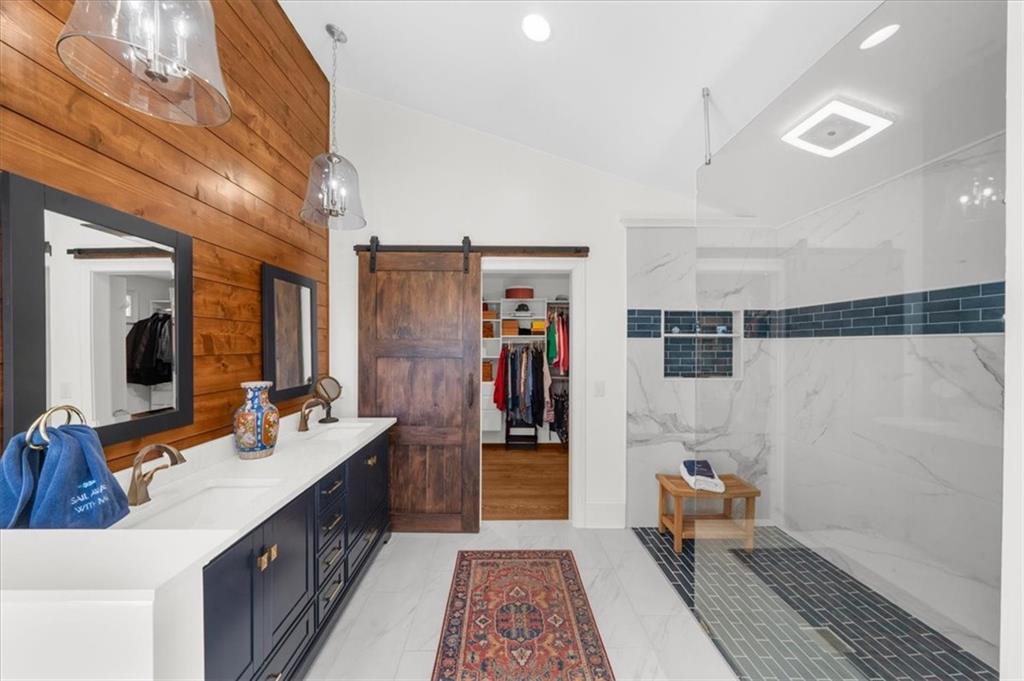 9230 Four Mile Creek Road Gainesville, GA 30506 - Photo 22 of 67 a large bathroom with a double vanity sink a large mirror and a shower