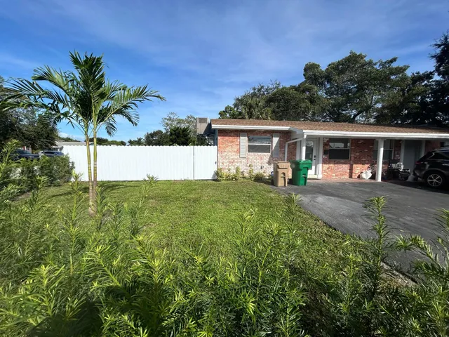 a front view of house with yard and trees in the background