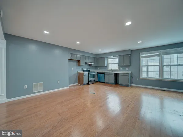 a view of empty room with wooden floor and windows