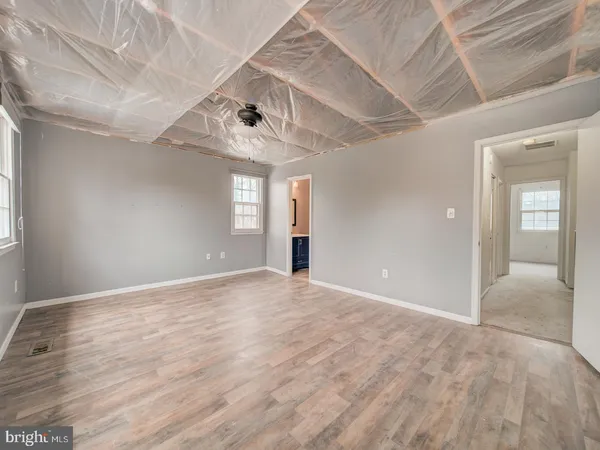 a view of an empty room with window and wooden floor