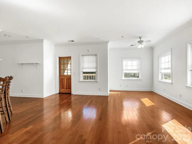 a view of a hallway with wooden floor and entryway