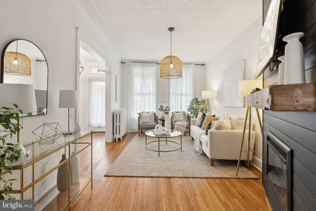 a living room with furniture a fireplace and a dining table with wooden floor