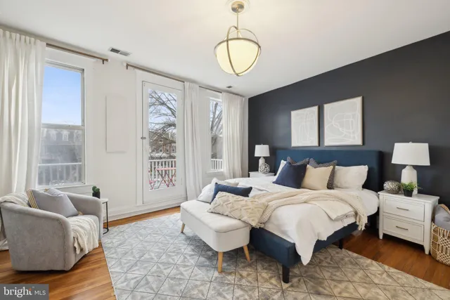 a spacious bedroom with a bed and glass window