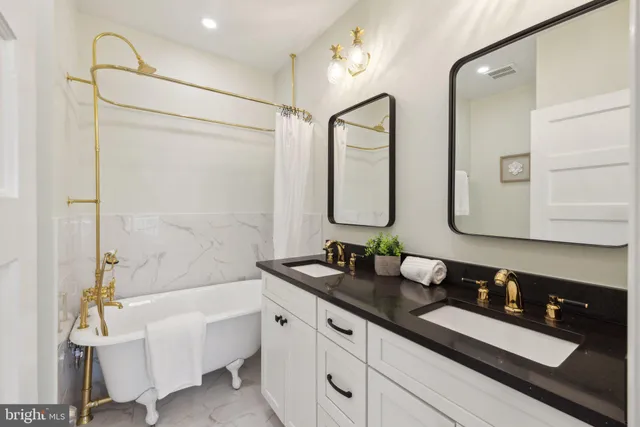 a bathroom with a double vanity sink mirror and bathtub