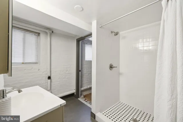 a bathroom with a sink a toilet a shower and a mirror