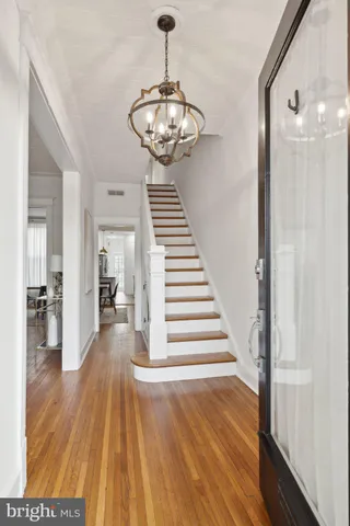 a view of a hallway with wooden floor and staircase