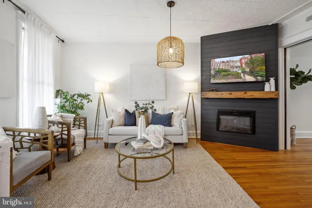 a living room with furniture a fireplace and a flat screen tv