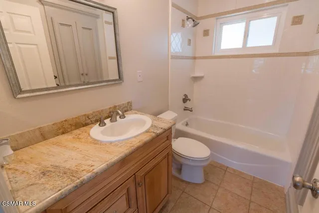 a bathroom with a granite countertop sink a toilet and shower