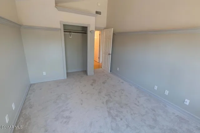 a view of an empty room with closet and window