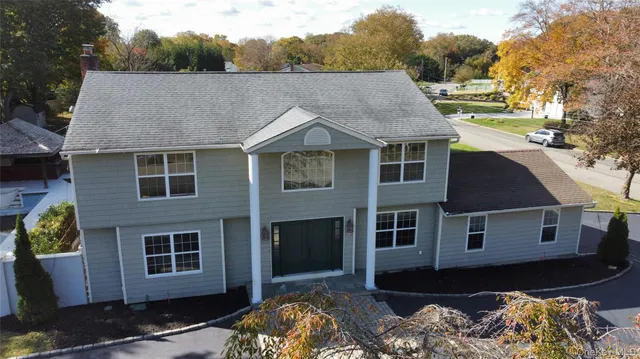 a aerial view of a house with a yard and balcony