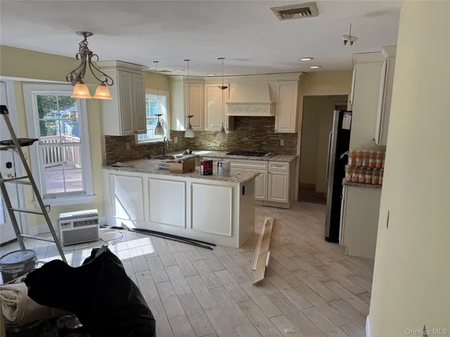 a kitchen with stainless steel appliances granite countertop a sink stove refrigerator and wooden floor