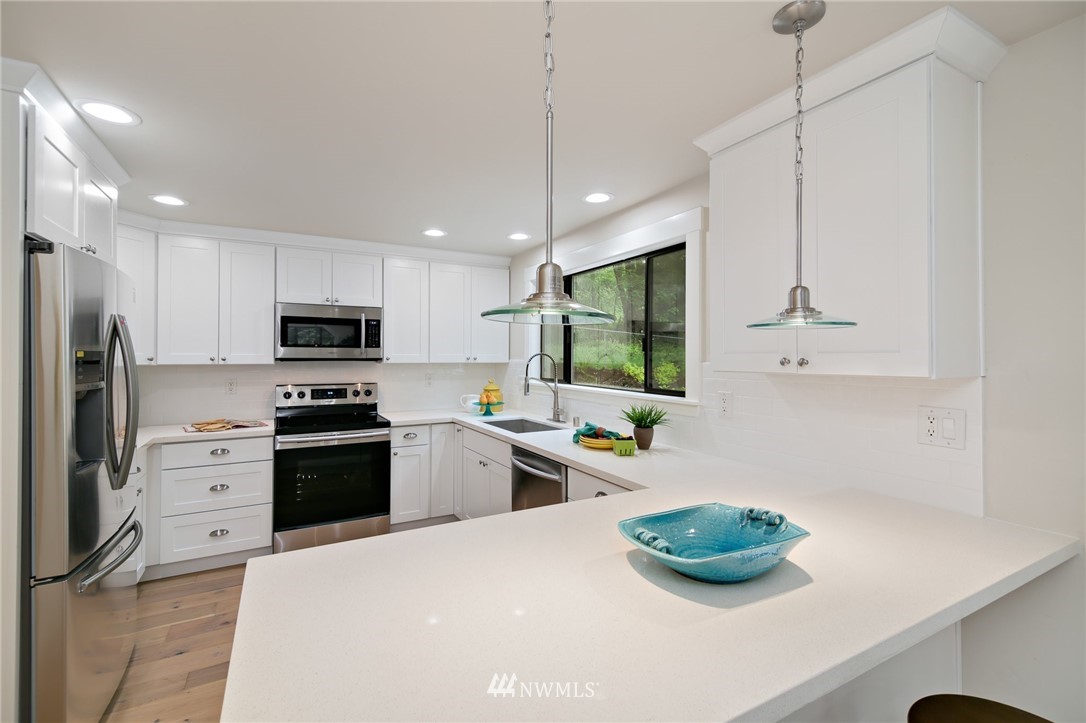 28505 Northeast Tolt Hill Road Carnation, WA 98014 - Photo 13 of 25 a kitchen with stainless steel appliances a sink a stove a refrigerator cabinets and a counter top space