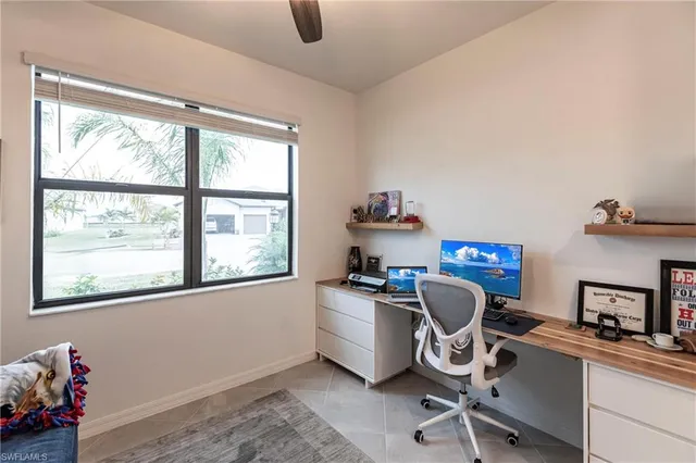 a view of a workspace with furniture and a window