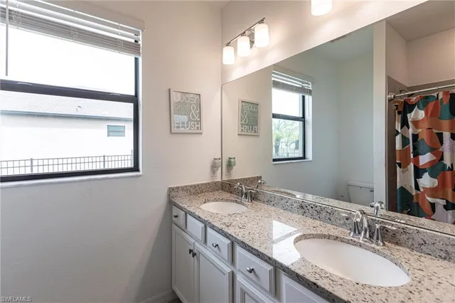 a bathroom with a granite countertop sink a mirror and a window