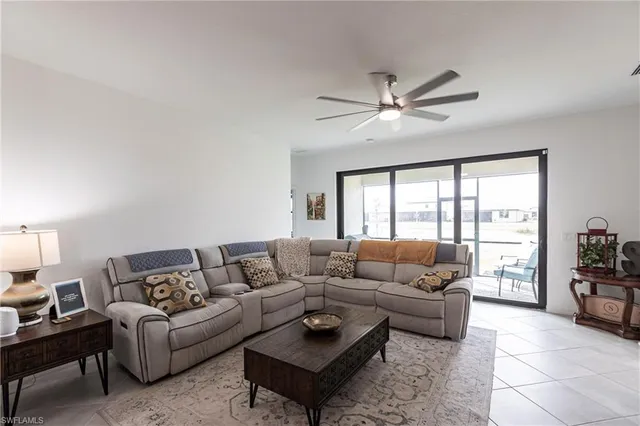 a living room with furniture and a large window with a rug
