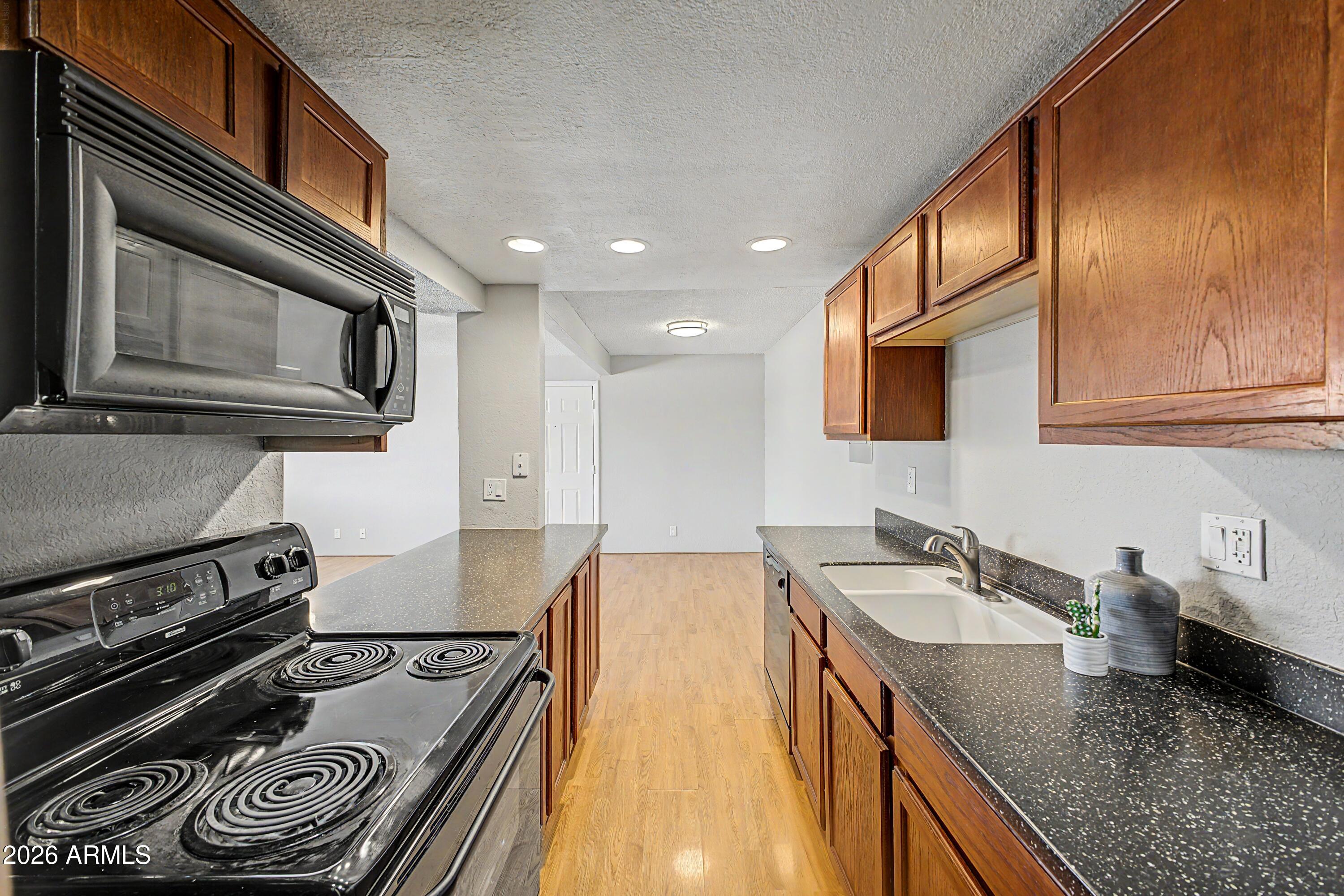 424 West Brown Road, Unit 248 Mesa, AZ 85201 - Photo 8 of 19 a kitchen with stainless steel appliances granite countertop a sink a stove and cabinets