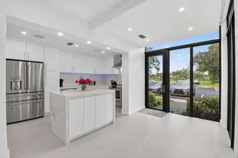a kitchen with refrigerator and white cabinets