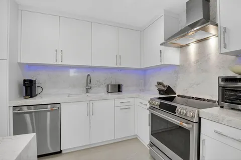 a kitchen with white cabinets and appliances