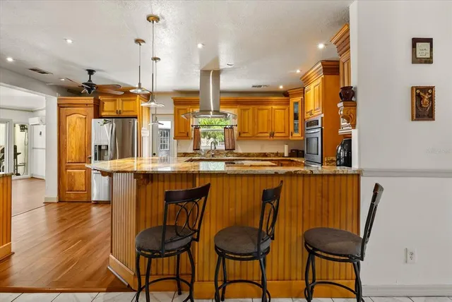 a kitchen with stainless steel appliances granite countertop a table chairs and a sink