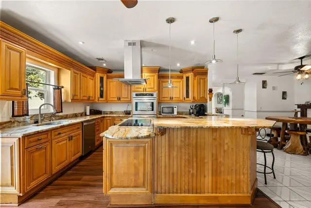 a kitchen with stainless steel appliances granite countertop wooden cabinets a sink and a stove
