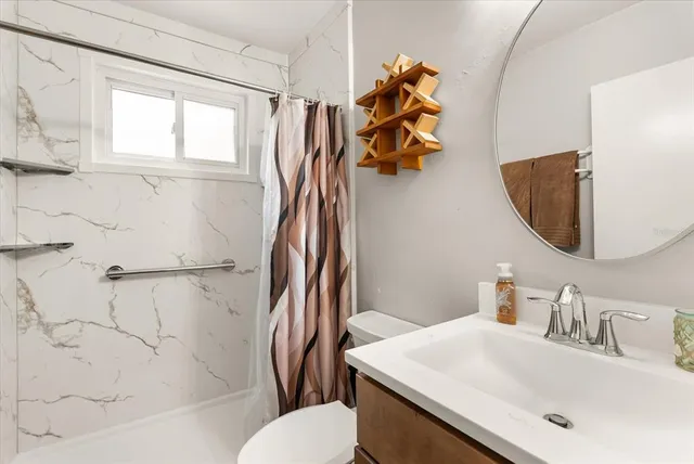 a bathroom with a sink toilet and shower
