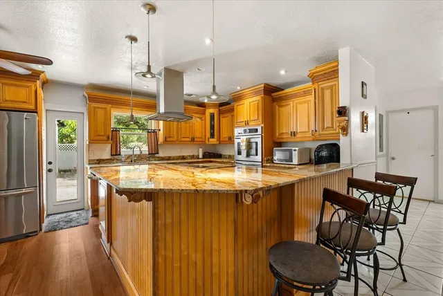a kitchen with stainless steel appliances granite countertop a sink and a refrigerator