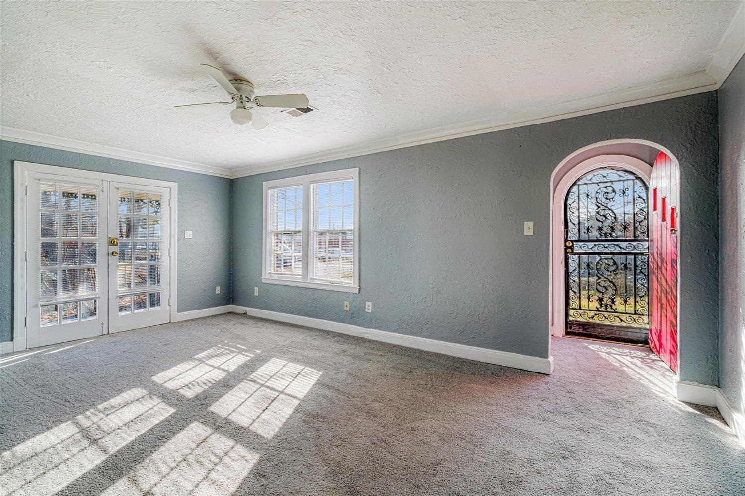 1114 Brownlee Road Memphis, TN 38116 - Photo 8 of 32 Empty room with a textured wall, french doors, a textured ceiling, light colored carpet, and ceiling fan