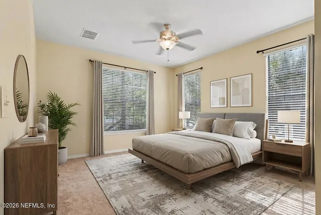 a bedroom with a large bed and a potted plant