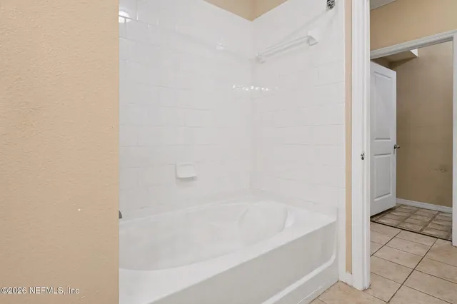 a bedroom with a bed mirror and window