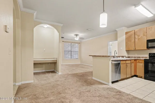 a view of a kitchen with a sink and dishwasher a refrigerator with white cabinets