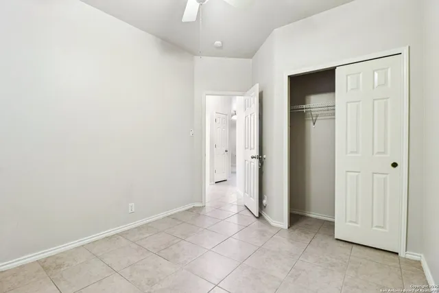 a view of an empty room with a window and a ceiling fan