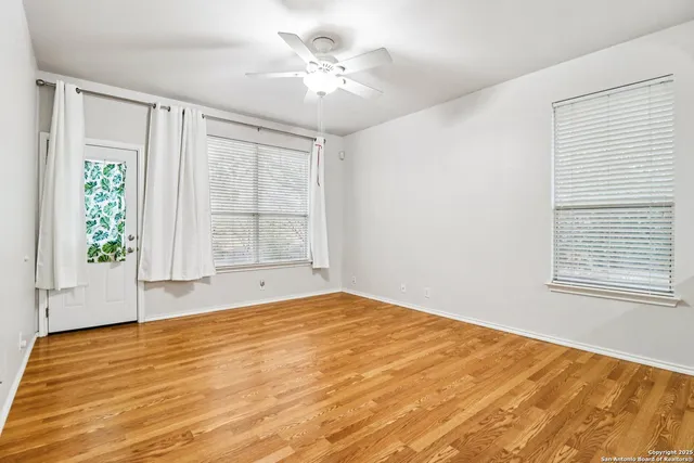 a view of kitchen and empty room with wooden floor