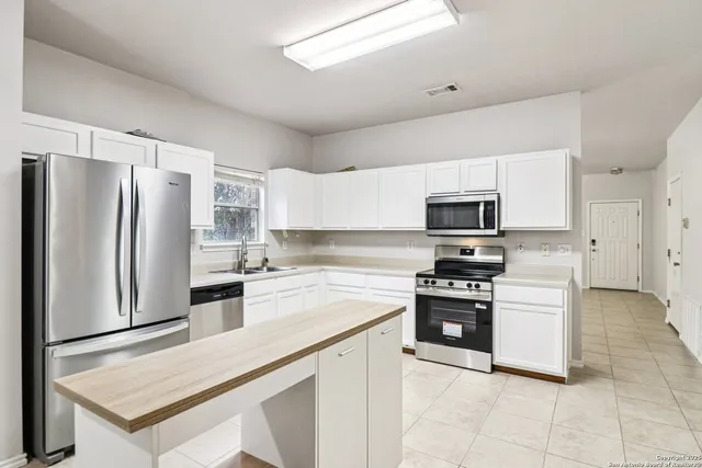 a kitchen with cabinets stainless steel appliances and a counter space