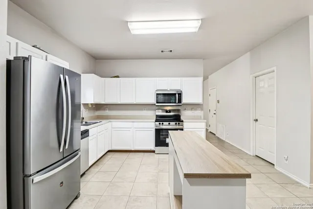 a kitchen with stainless steel appliances a refrigerator sink and stove