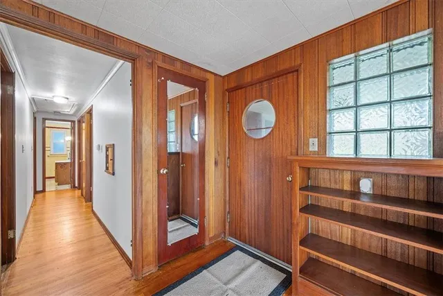 a view of a hallway with wooden floor and windows