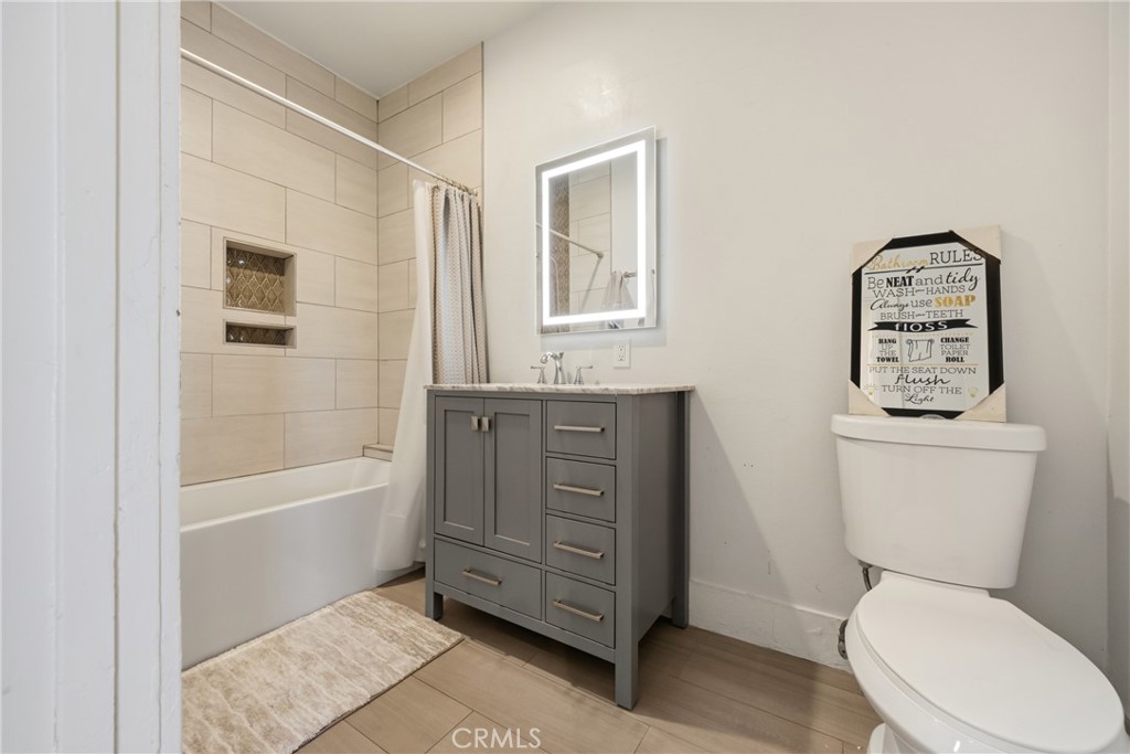325 East 14th Street Long Beach, CA 90813 - Photo 17 of 21 a bathroom with a granite countertop toilet a sink and bathtub