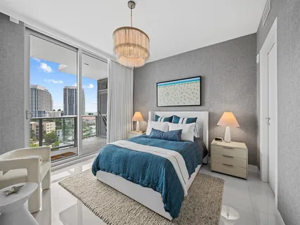 a bedroom with a large bed and a chandelier