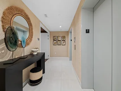 a view of a hallway with couches and dining table with wooden floor