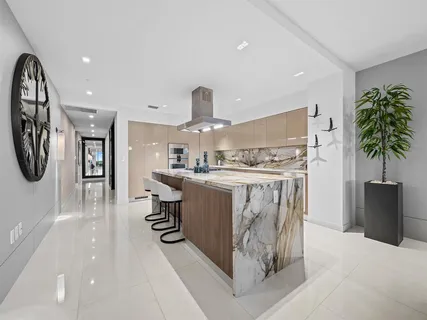 a kitchen with stainless steel appliances kitchen island granite countertop a table chairs sink and cabinets